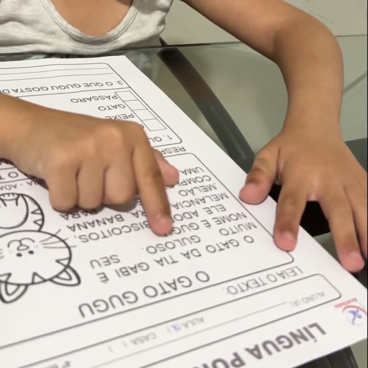 Criança lendo um pequeno texto do material